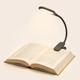 A clip-on book light glowing over an open book